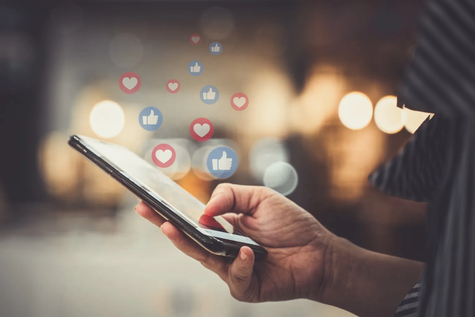 Person on smartphone, with social media icons floating around it.