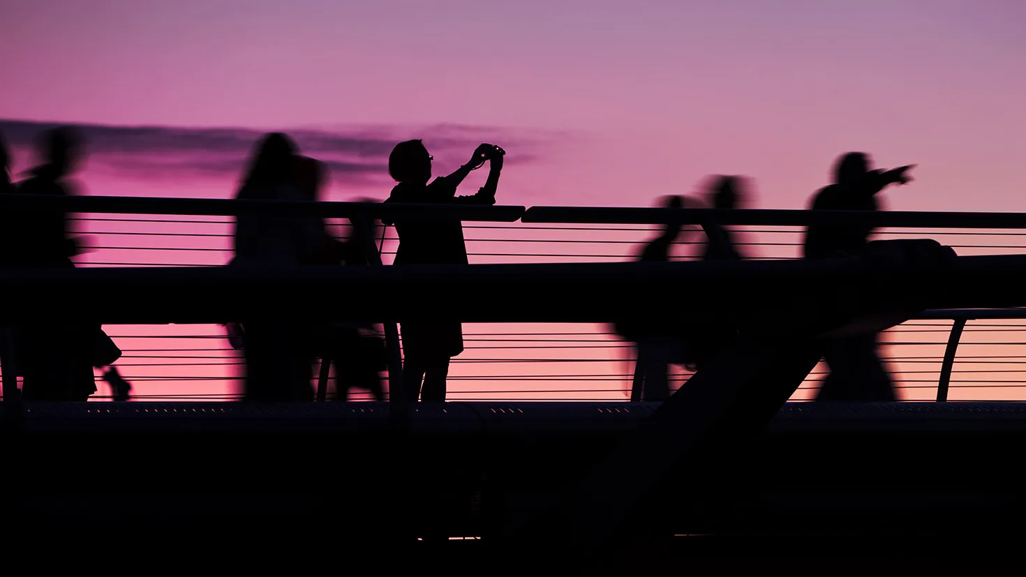 Silhouette of people on a bridge