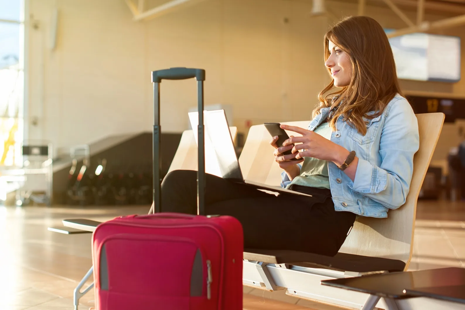 Woman with red suitcase in an airport