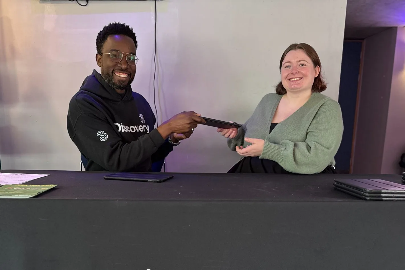 Man handing over iPad to woman.
